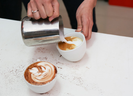 Barista making a cup of beautiful latte art coffeeの写真素材