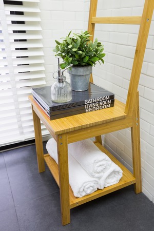 Interior decoration of modern contemporary toilet with wooden chair, books, and towelの写真素材