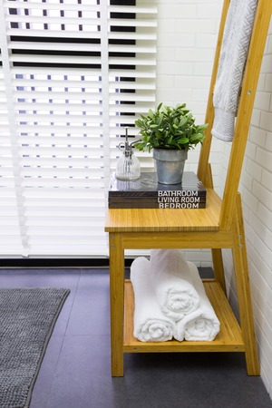 Interior decoration of modern contemporary toilet with wooden chair, books, and towelの写真素材