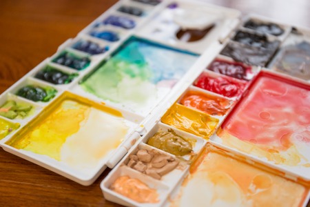 Paintbrush and paint palette with colorful mixed watercolorの写真素材