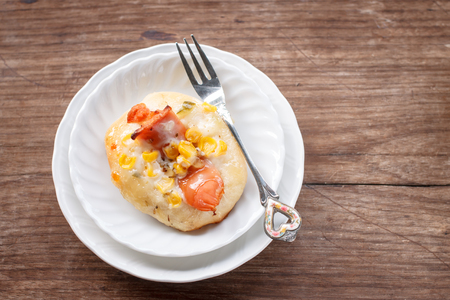 fresh mini sweet sausage cheese bread with corn served on small white plate in tea timeの写真素材