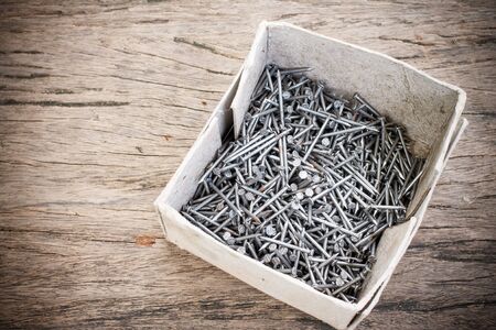 Box of old metal nails on wood backgroundの写真素材