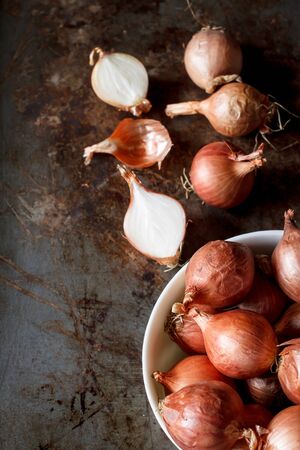 still life image of organic red shallot put on old grunge tray background image dark tone.の写真素材