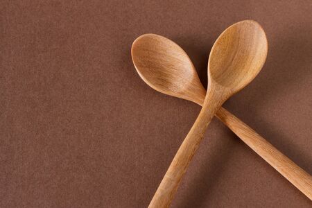 Old wooden cooking spoon on brown backgroundの写真素材