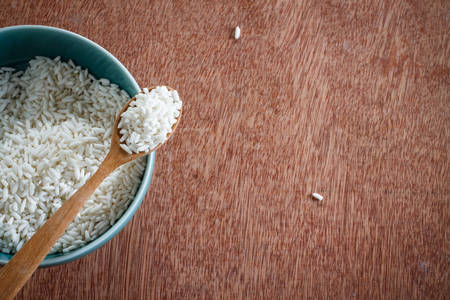 Jasmine rice in bowl put on old wood backgroundの写真素材