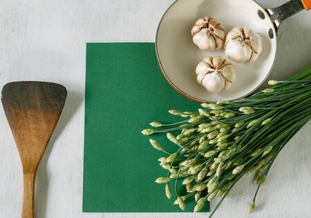 Garlic chives with garlic prepare for cooking put on vintage table, food background and green paper...