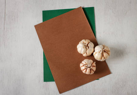 Organic three garlic for cooking put on vintage table, food background and green paper for noteの写真素材