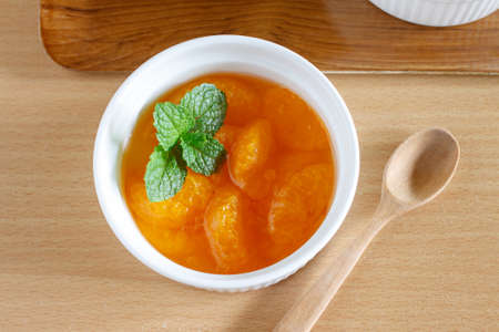 Mandarin orange fruit in syrup served in white cupの写真素材