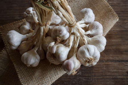 Bunch of garlic put on old wood image dark tone
