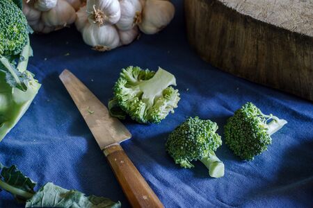 organic broccoli fresh from fram with old cutting board and garlic prepare for cook, image dark tone