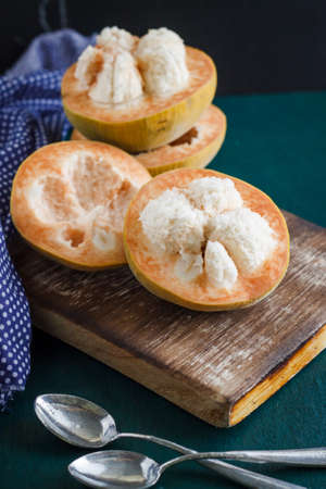 Thai fruit: Santol cut put on old cutting board with spoon and napkin, image dark tone and soft focusの写真素材