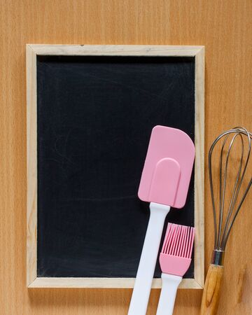 Blackboard on wooden surface and baking tools. Bakery background with blackboard for copy space.の写真素材