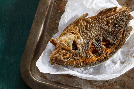 Fried Tilapia fish fried put on old tray.の写真素材