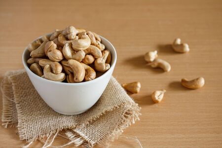 cashew nut in a white bowl with sackcloth.の写真素材