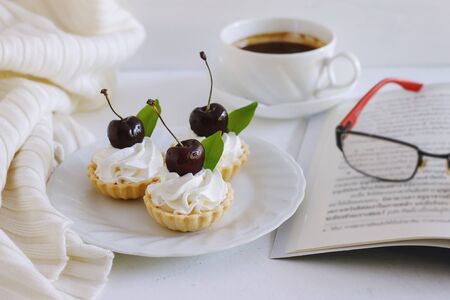 Delicious cherry tart with whipping cream and black coffee on white background.の写真素材