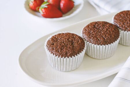 Chocolate cupcakes on white plate and fresh strawberry.の写真素材