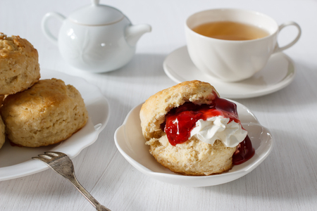 Traditional British Scones with clotted cream, strawberry jam and a cup of tea.の写真素材