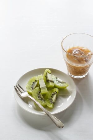 kiwi fruit served on small plate with cole iced coffee.の写真素材