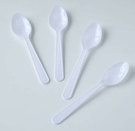 lot of white plastic coffee spoons on white backgroundの写真素材