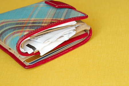 Close-up of a wallet which contains some cards and lots of receipts  