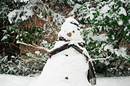 A snowman in the winter with snowflakes falling down from the sky の写真素材