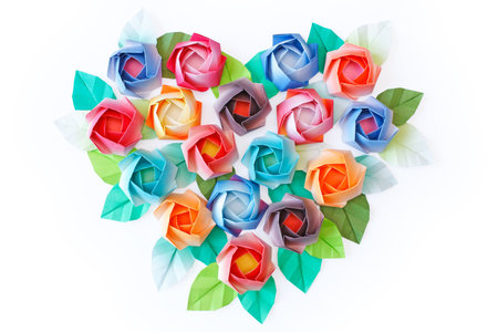 Paper roses arranged in a heart shaped on a white backgroundの写真素材