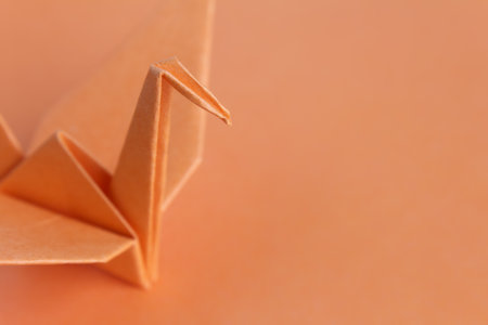 An orange paper bird on an orange background, shallow depth of fieldの写真素材