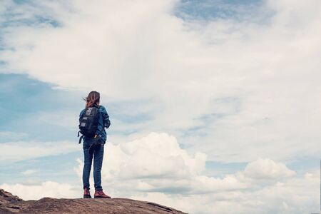 Asian woman standing outside looking at the beauty of natural stone, relaxed mood.の写真素材