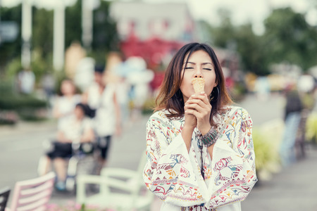 Photos of Asian women eating ice cream and  stand in hot weather. The emotional happiness,Focus on handsの写真素材