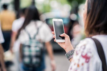 Photos of Asian women using cell phones in the outdoors, Focus on handsの写真素材
