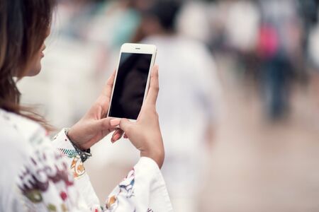 Photos of Asian women using cell phones in the outdoors,Focus on Focus on handsの写真素材