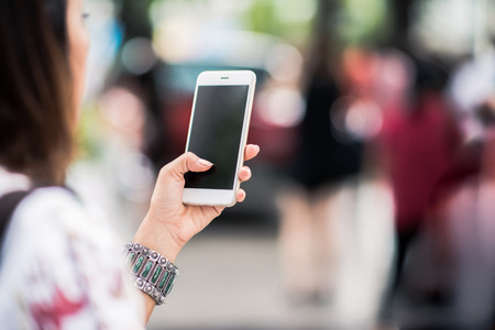 Photos of Asian women using cell phones in the outdoors, Focus on handsの写真素材