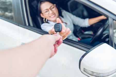 Asian women are very happy. After she got the car Focus on the keys.の写真素材