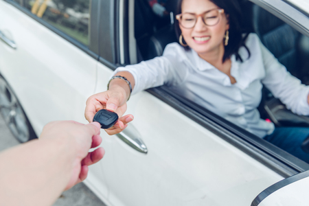 Asian women are very happy. After she got the car Focus on the keys.の写真素材