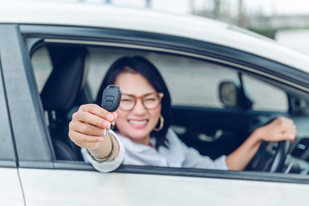 Asian women are very happy. After she got the car Focus on the keys.の写真素材