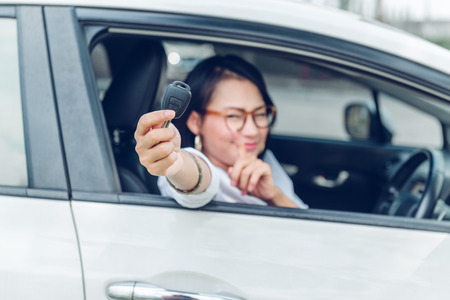 Asian women are very happy. After she got the car Focus on the keys.の写真素材