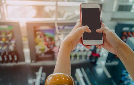 Pictures of Asian women hand holding a smartphone with a screen, space for text messages or your content.Focus on handsの写真素材