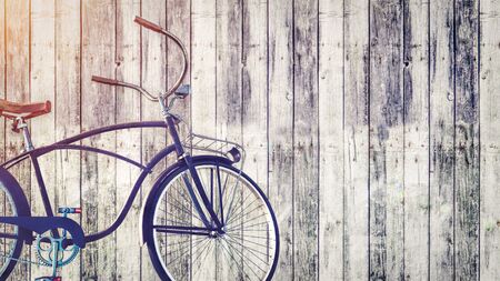 Vintage bicycle parked beside wooden wall.の写真素材