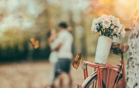 Rose is on the bicycle.Men and women show their love in the background.の写真素材
