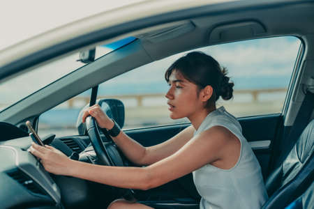 Relaxed happy petite woman on travel vacation. siting on the car and looking for a route. lifestyle and people concept.の写真素材