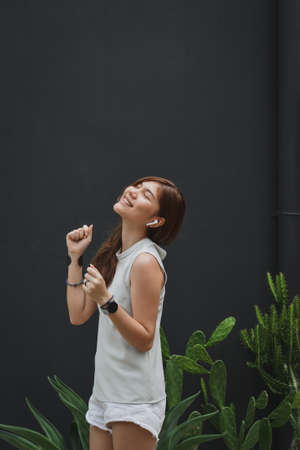 Happy Girl Enjoying Music In Airpods And dancing Favourite Song, Relaxing travel outside.の写真素材