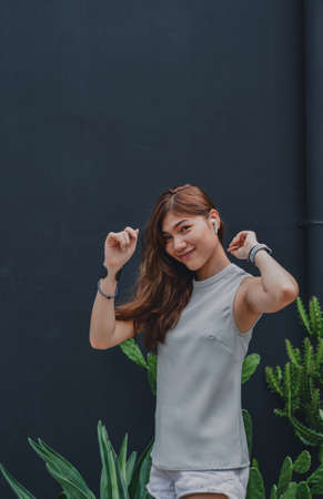 Happy Girl Enjoying Music In Airpods And dancing Favourite Song, Relaxing travel outside.の写真素材