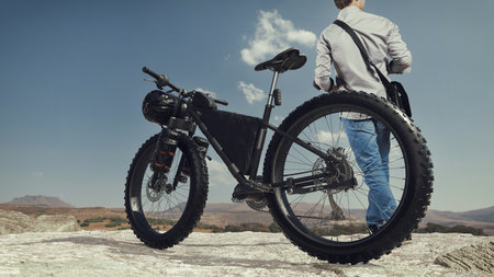 Man looking at beautiful misty mountains Enjoy panoramic mountain views. with bicycles ready to...