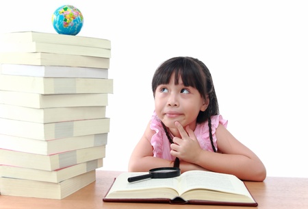 Student little girl reading with magnifying glass look the globeの写真素材
