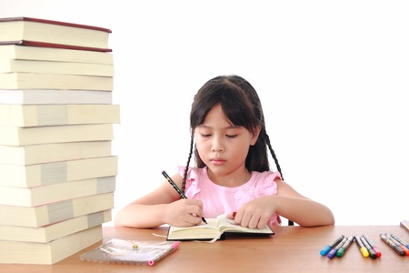 Asian little girl draw on a book isolated on a over white backgroundの写真素材