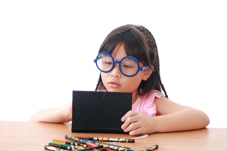 Asian little girl draw on a book isolated on a over white backgroundの写真素材
