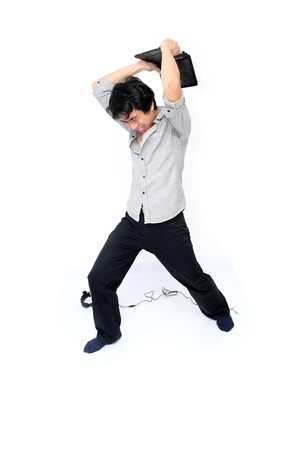 Young asian businessman trying to break his laptop.の写真素材