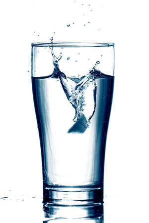 Water splash ice dropped in a glass cool toneの写真素材