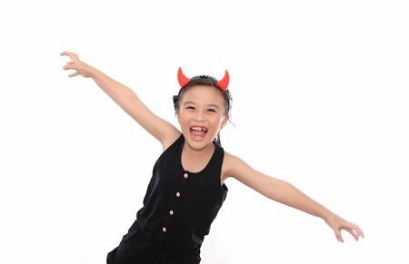 Scary cute little asian girl in black Halloween costume.の写真素材