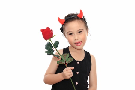 Scary cute little asian girl in black Halloween costume give red rose.の写真素材